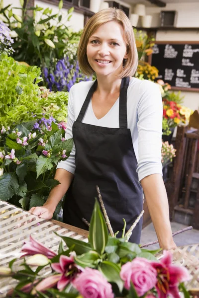 Женщина в цветочном магазине улыбается — стоковое фото