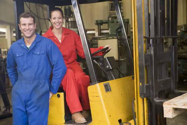 Two warehouse workers with forklift — Stock Photo, Image