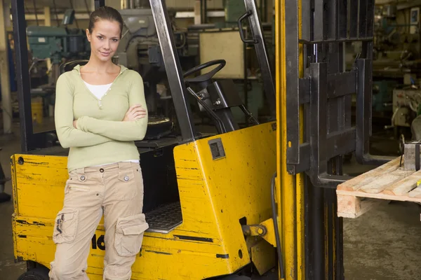 Warehouse worker standing by forklift — Stock Photo, Image
