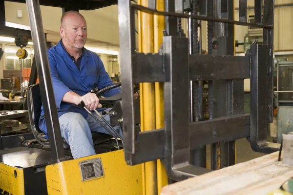 Warehouse worker in forklift — Stock Photo, Image