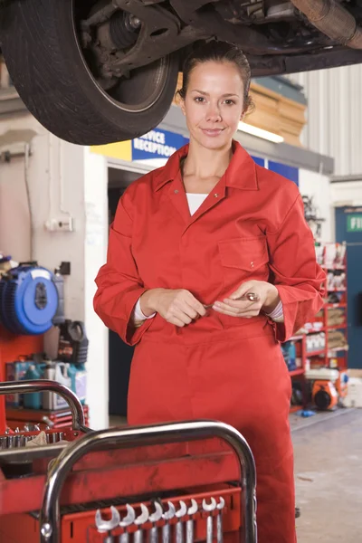 Mechanic werken onder auto glimlachen — Stockfoto
