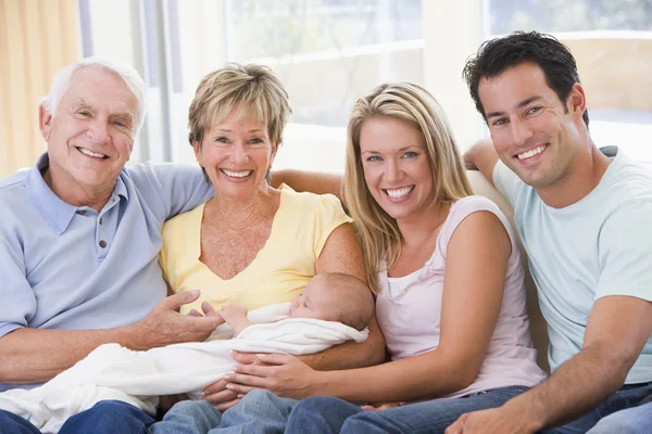 Familie in woonkamer met baby glimlachen — Stockfoto