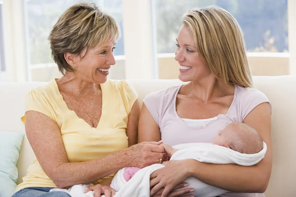 Mormor och mamma i vardagsrummet med baby leende — Stockfoto