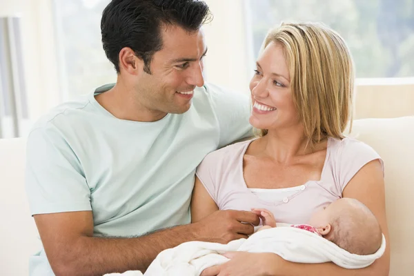 夫妻在客厅里带着宝宝的笑容 — 图库照片