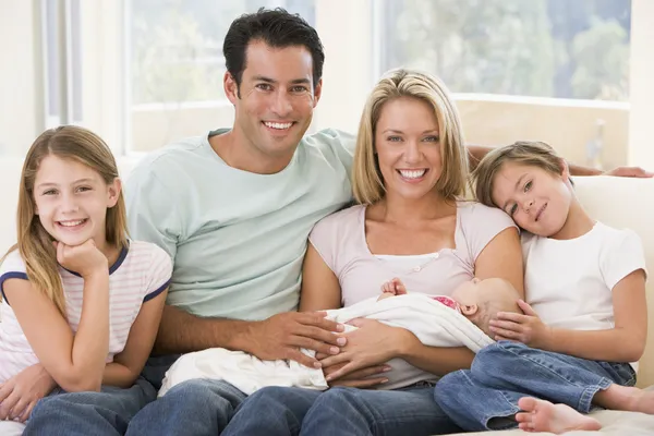Сім'я у вітальні з дитиною посміхається — стокове фото