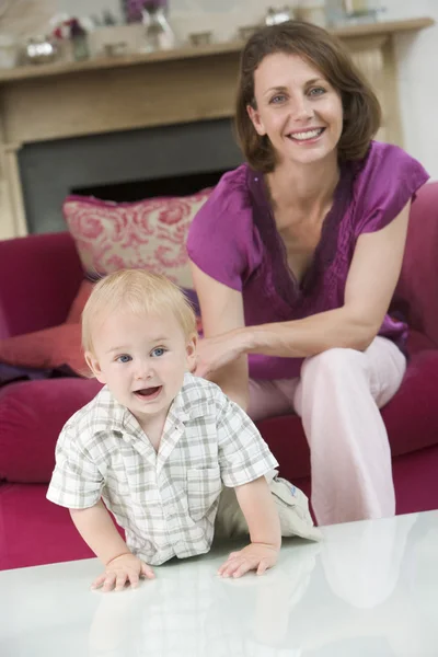 Mutter im Wohnzimmer mit lächelndem Baby — Stockfoto