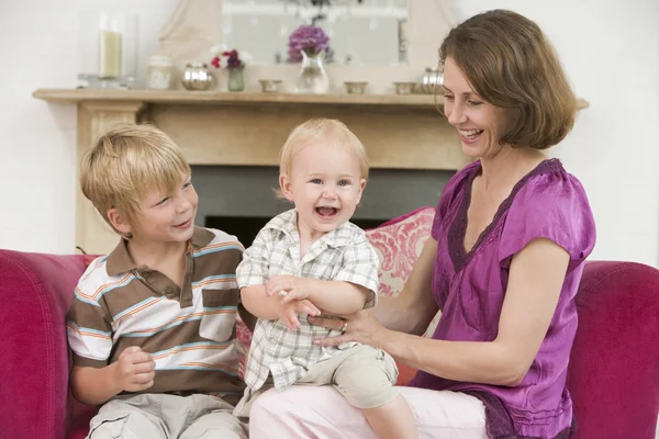 在客厅的婴儿和微笑的小男孩的母亲 — 图库照片