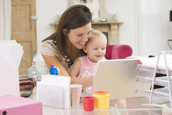 Madre y bebé en la oficina del hogar con el ordenador portátil — Foto de Stock