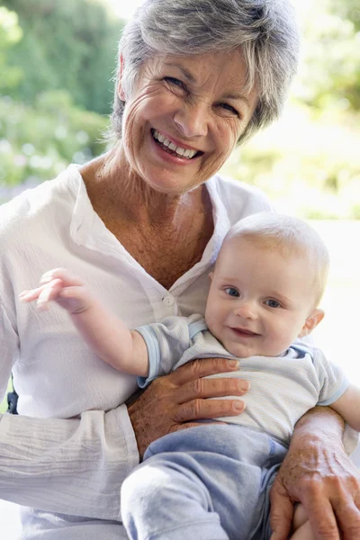 Grandmother outdoors on patio with baby smiling — Stock Photo, Image