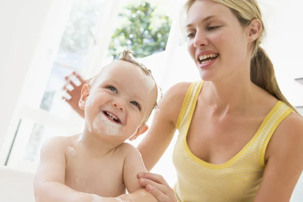 Moeder geven baby bubbelbad glimlachen — Stockfoto