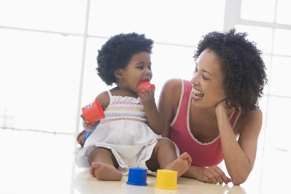 Mother and daughter indoors playing and smiling — Stock Photo, Image