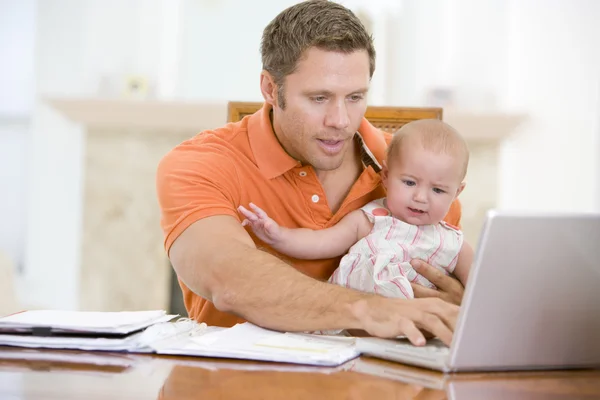 Vader en baby in eetzaal met laptop — Stockfoto