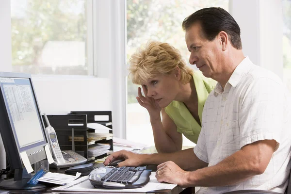 Couple in home office at computer frowning — Stock Photo, Image