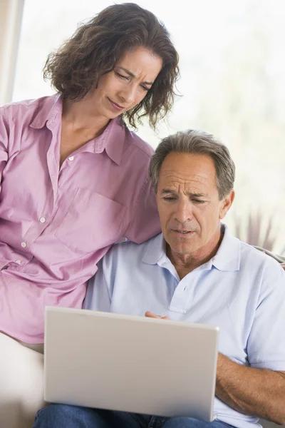 Par i vardagsrum med laptop — Stockfoto