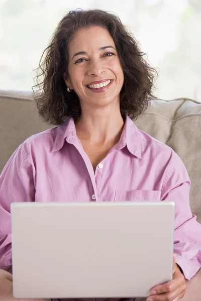 Kobieta w salonie z laptopa uśmiechający się — Zdjęcie stockowe