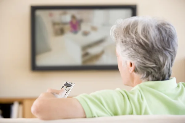 Man watching television using remote control — Stock Photo, Image