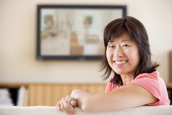 Woman watching television smiling — Stock Photo, Image