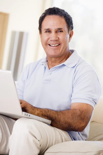 Adam Gülümseyerek Laptop Ile Oturma Odasında — Stok fotoğraf