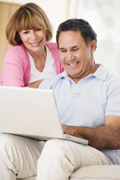 Paar im Wohnzimmer mit Laptop lächelnd — Stockfoto