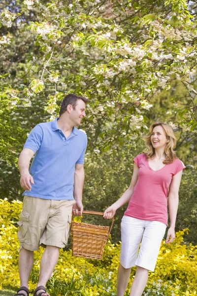 Пара прогулок на свежем воздухе с улыбкой в корзине для пикника — стоковое фото