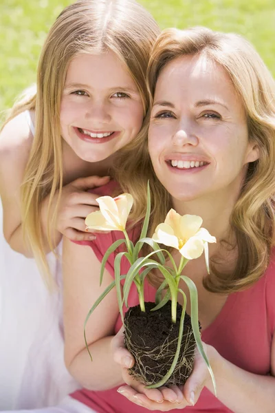 Matka Córka Zewnątrz Gospodarstwa Kwiat Uśmiechający Się — Zdjęcie stockowe