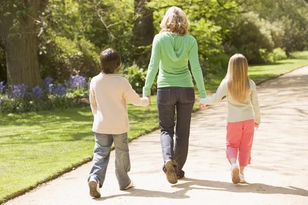 Annesi ve iki genç çocuk tutan eller SMIL yolda yürürken — Stok fotoğraf