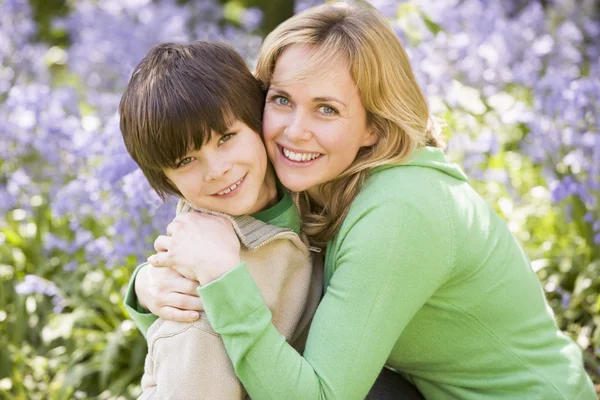 Mother and son outdoors embracing and smiling — Stock Photo, Image