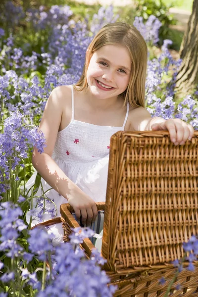 年轻的女孩坐在户外一起野餐篮微笑 — 图库照片