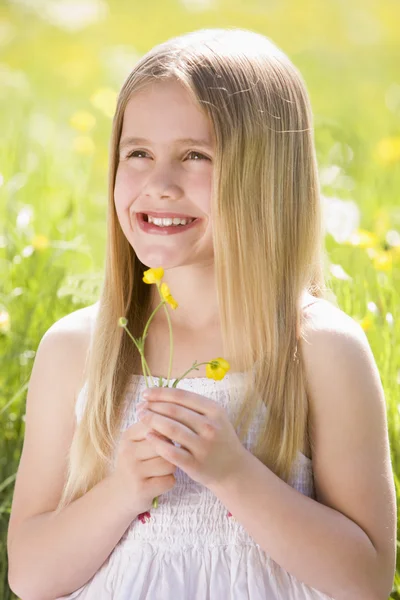 Νεαρό Κορίτσι Που Κάθεται Εξωτερικούς Χώρους Κρατώντας Χαμογελώντας Λουλούδι — Φωτογραφία Αρχείου
