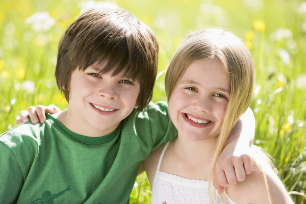 Twee Jonge Kinderen Zitten Buiten Arm Arm Glimlachen — Stockfoto