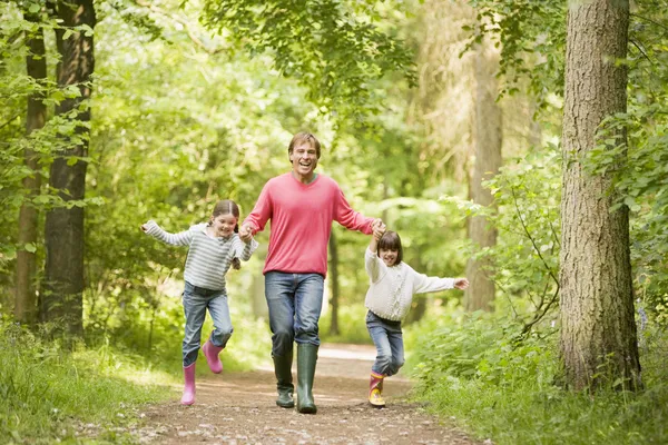 Father and daughters walking on path holding hands — Stock Photo ...