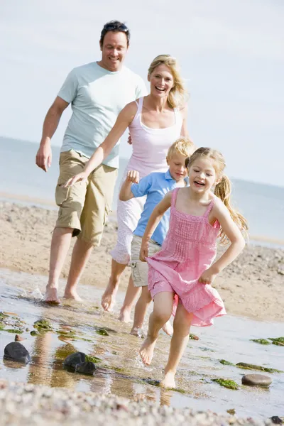 运行在海滩微笑的家庭 — 图库照片