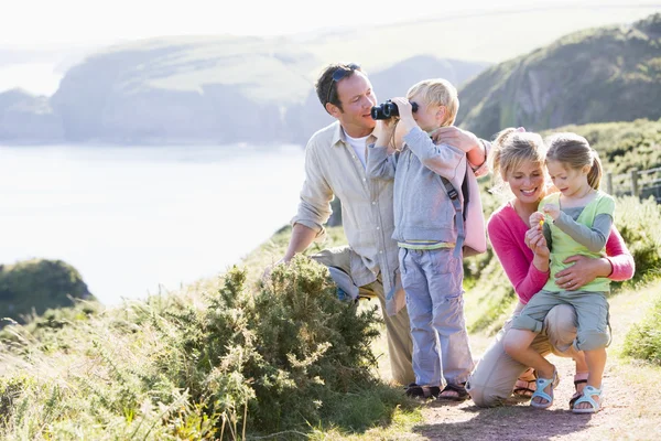 Familie op cliffside pad met behulp van verrekijkers en glimlachen — Stockfoto