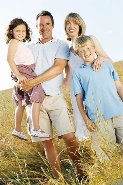 Família em pé ao ar livre sorrindo — Fotografia de Stock