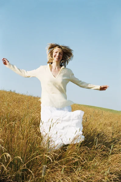 Woman running outdoors smiling — Stock Photo, Image