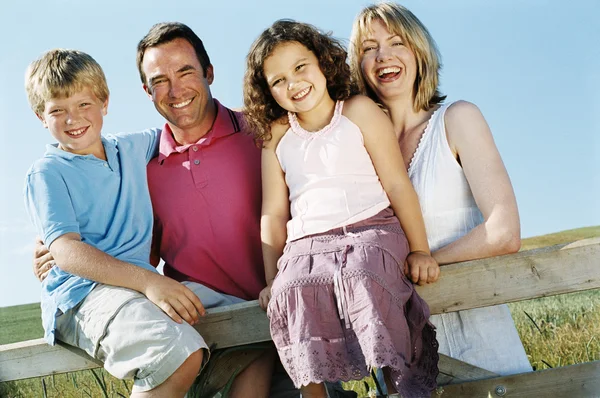屋外笑みを浮かべてフェンスの上の家族 — ストック写真