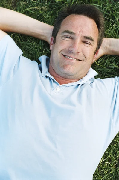 Hombre acostado al aire libre sonriendo — Foto de Stock