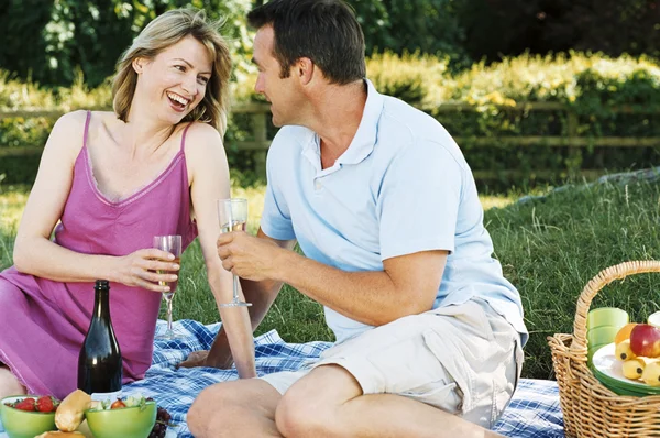 Paret sitter utomhus med picknick leende — Stockfoto