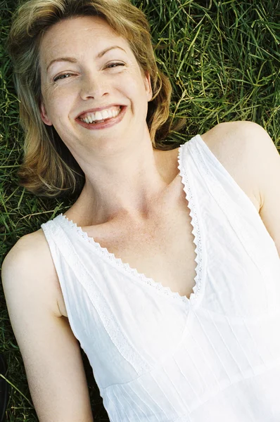 Vrouw liggen buiten lachende — Stockfoto