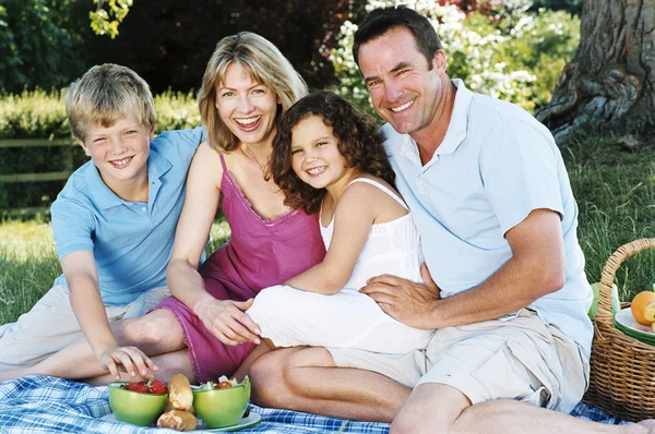 Familia Sentada Aire Libre Con Picnic Sonriendo — Foto de Stock