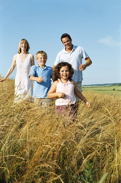 Family running outdoors smiling — Stock Photo, Image