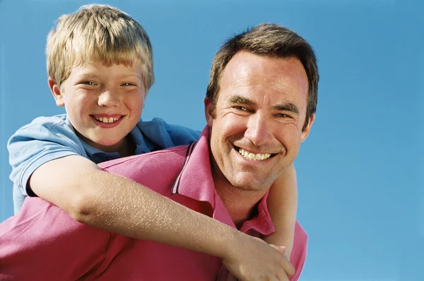 Father Giving Son Piggyback Ride Outdoors Smiling — Stock Photo, Image