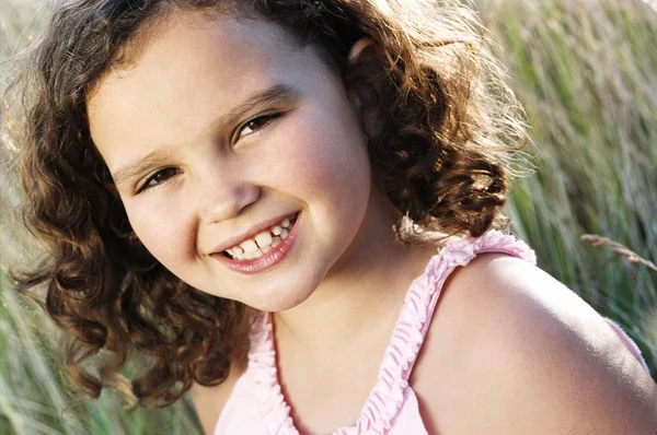 Chica joven sentada al aire libre sonriendo — Foto de Stock