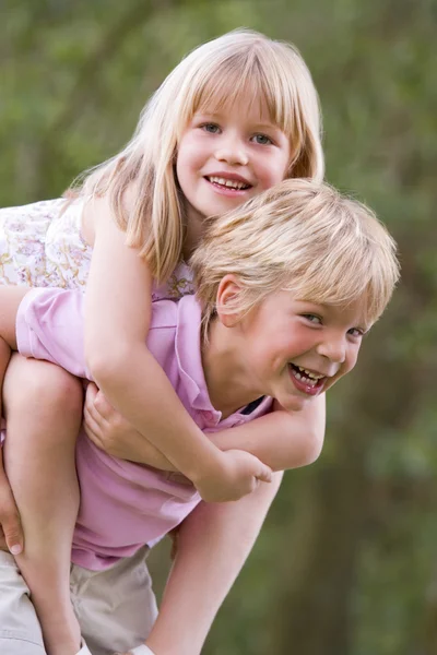 Kleiner Junge Gibt Junges Mädchen Huckepack Freien Lächelnd — Stockfoto