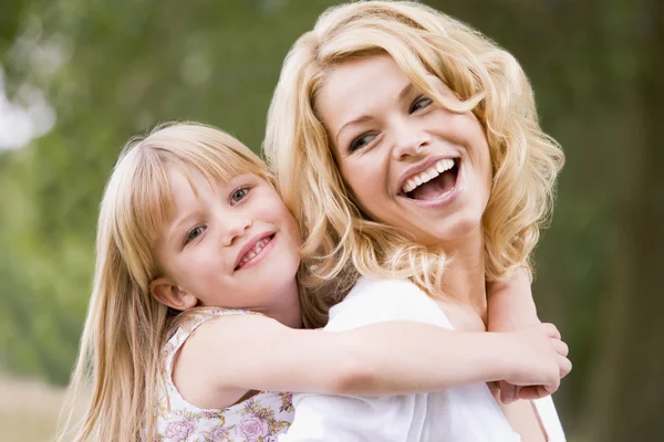 Madre sosteniendo hija al aire libre sonriendo —  Fotos de Stock