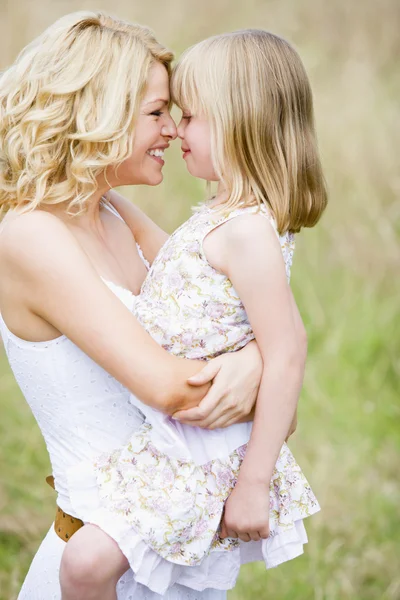 Matka drží dceru venku s úsměvem — Stock fotografie
