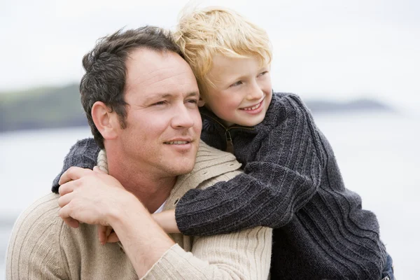 Otec a syn na pláži s úsměvem — Stock fotografie