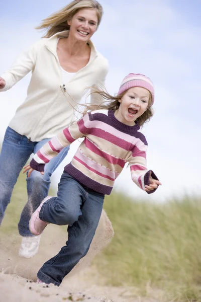 Madre e hija corriendo en la playa sonriendo — Foto de Stock