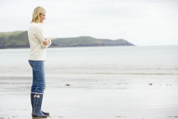 Mulher de pé na praia sorrindo — Fotografia de Stock
