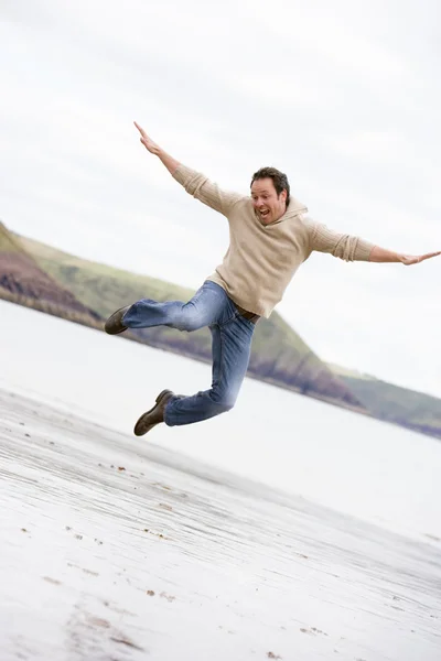 男子跳上海滩微笑 — 图库照片